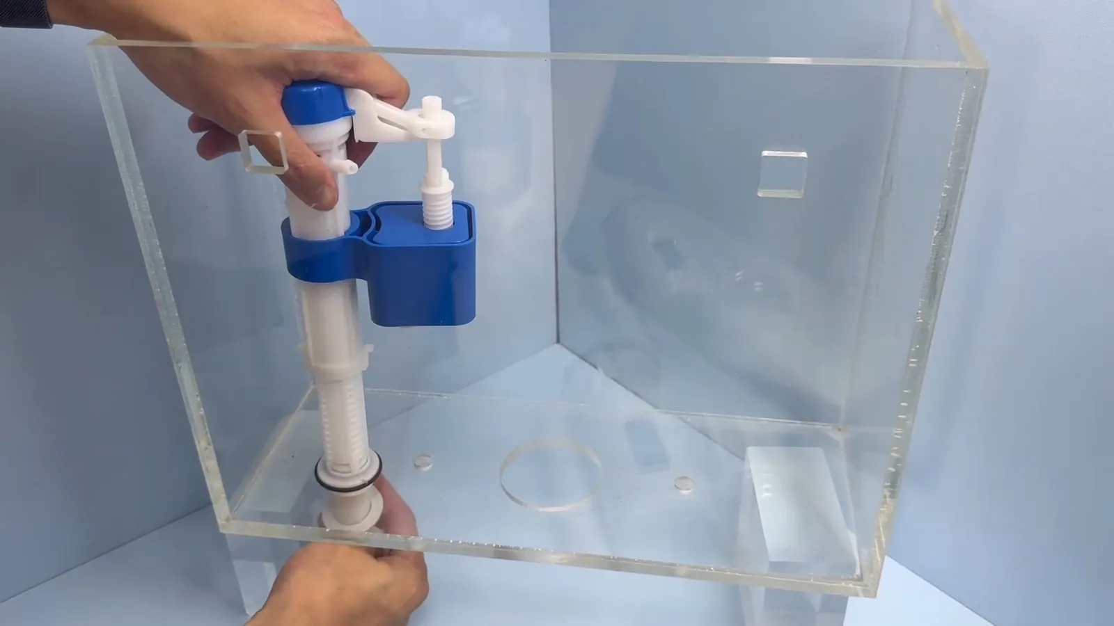 Clear acrylic toilet tank model showing the fill valve and float inside