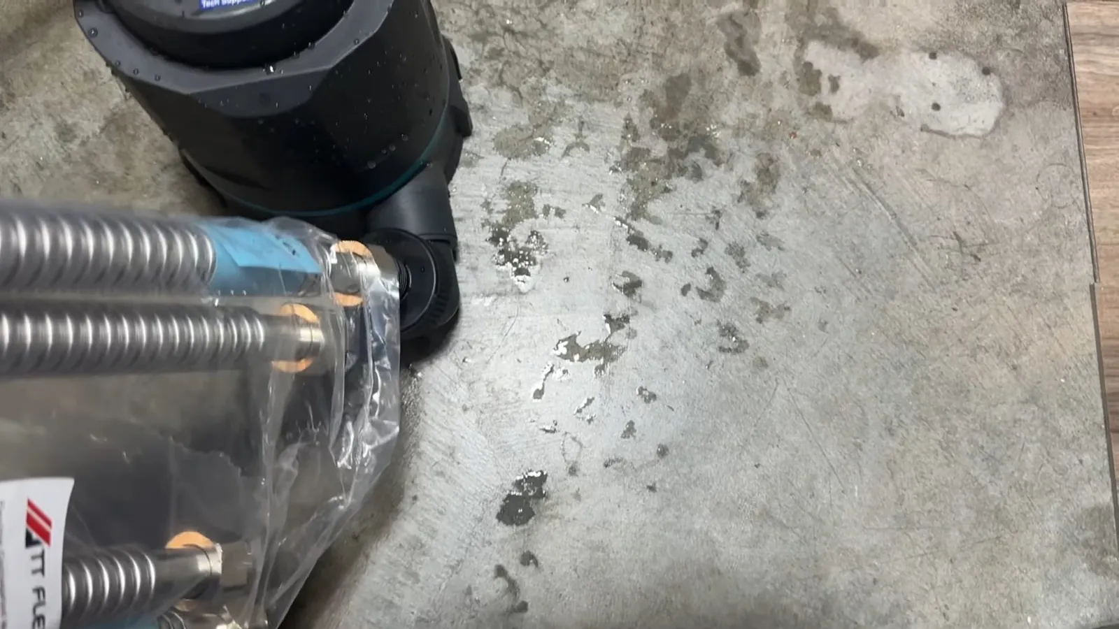 Corrugated gas connector and pipe fittings lying on a concrete floor