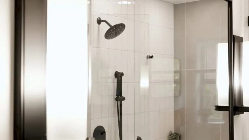 Glass shower enclosure with a rain showerhead, a hand shower and black fixtures on white tile