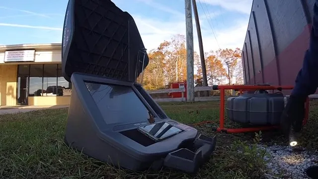 Sewer camera reel case sitting on grass between buildings