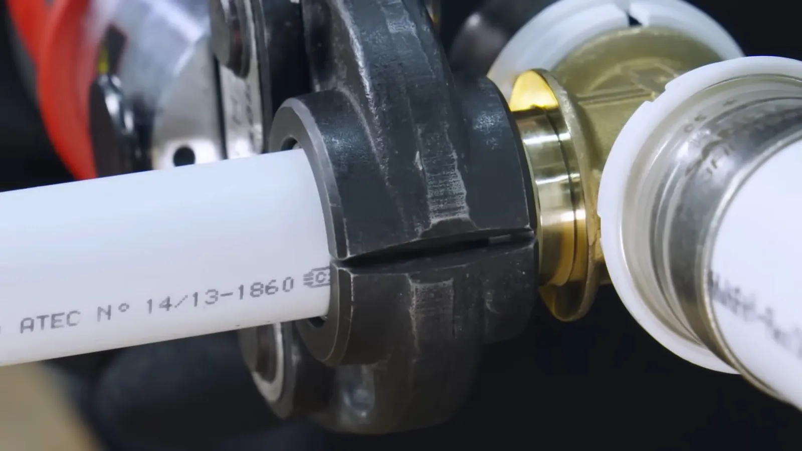 White pipe being pressed into a brass fitting with a press tool